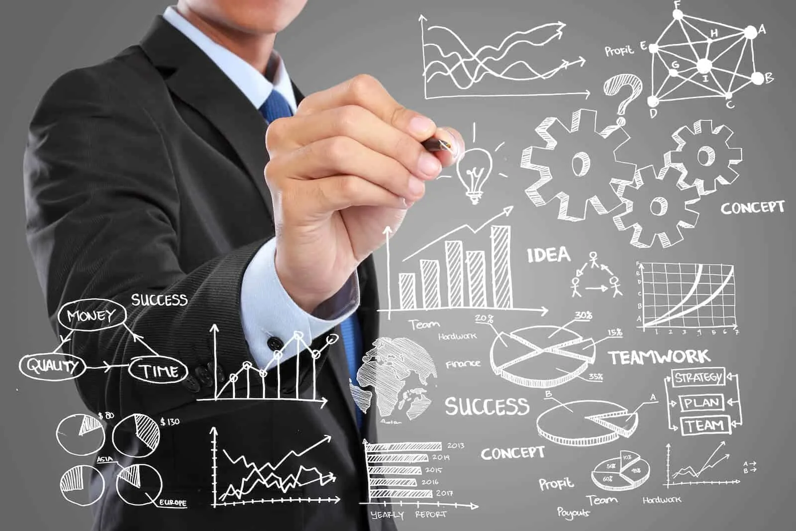 Businessman drawing business strategy sketches of charts, gears, ideas and success on a gray board