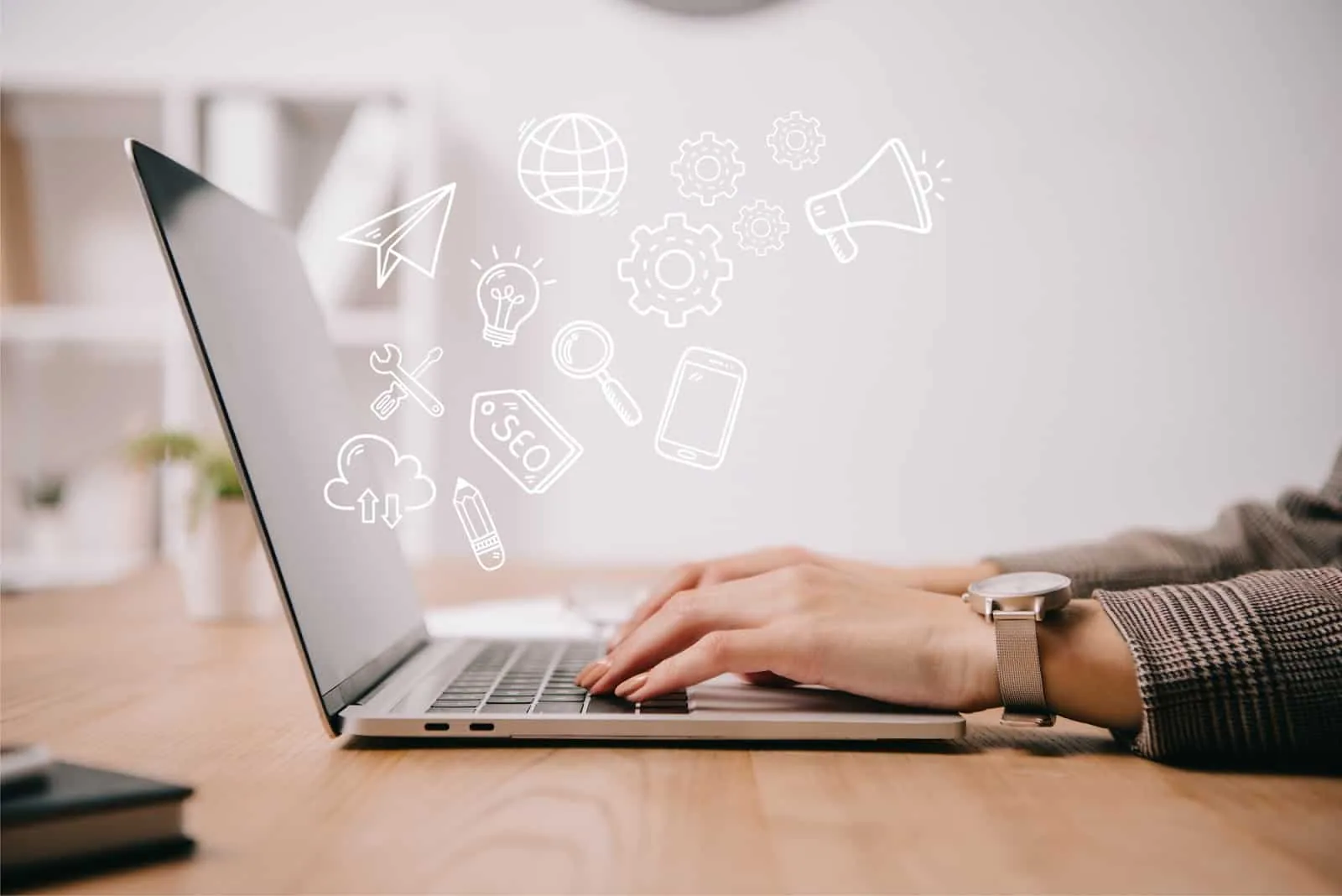 Hands typing on a laptop with digital marketing icons for SEO, email, ideas and promotion floating above